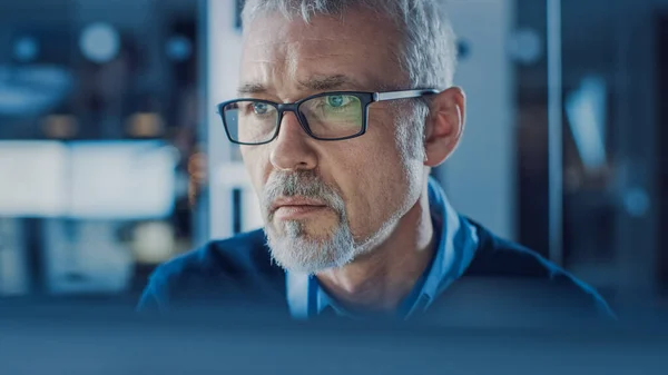 2007 년 10 월 1 일에 확인 함 . Portrait of Handsome Middle Aged Engineer Wearing Glasses Works on Personal Computer. 배경의 고등 과학 기술 시설에서 — 스톡 사진
