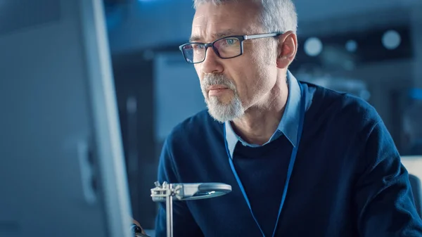 Elektronisk vedlikeholdsingeniør Solding Motherboard, Microchip and Circuit Board, ser gjennom forstørrelsesglass, konsultasjon Personlig datamaskin. Elektronisk reparasjon og prøving – stockfoto