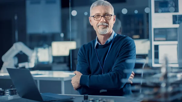 Professionelle Elektronik-Design-Ingenieur Brille trägt funktioniert auf Laptop-Computer im Forschungslabor. Im Hintergrund Motherboards, Leiterplatten, Roboterkomponenten für die Schwerindustrie — Stockfoto