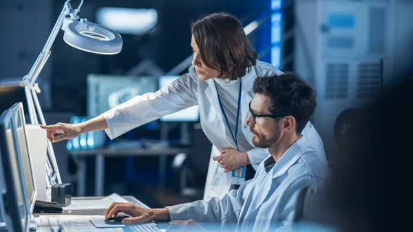 Engenheiro de desenvolvimento de máquinas trabalhando no computador em sua mesa, conversa com o gerente de projeto, mostra o componente do protótipo. Equipe de Profissionais Trabalhando no Laboratório de Design Industrial Moderno — Fotografia de Stock