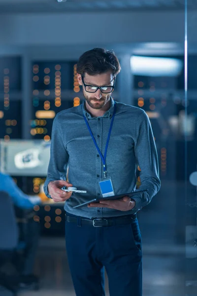 In Technology Research Facility: Chief Engineer Stands in the Middle of the Lab and uses Tablet Computer (em inglês). Equipe de Engenheiros Industriais, Desenvolvedores Trabalhar no projeto do motor Use Whiteboard Digital e — Fotografia de Stock