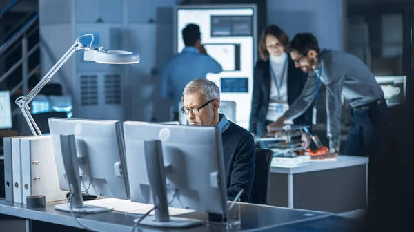 Colpo di ingegnere industriale che lavora nel centro di sviluppo del laboratorio di ricerca, utilizzando il computer. In background Laboratorio di Sviluppo Tecnologico con Scienziati, Ingegneri che lavorano — Foto Stock