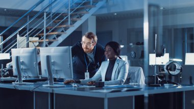 Elektronik Geliştirme Mühendisi Bilgisayar üzerinde çalışıyor, Proje Yöneticisi ile konuşuyor. Profesyonel Ekip Modern Endüstriyel Mühendislik Tasarımı için Makine Öğrenme ve Sinirsel Ağ Kullan. 