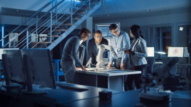 Elektronik Geliştirme Mühendisleri Ekibi masasında Robot Kolu Prototipi üzerinde çalışıyor. Ultra Modern Endüstriyel Tasarım, Makine Öğrenme, Yapay Zeka ve Sinirsel Ağ Üzerinde Çalışan Uzmanlar