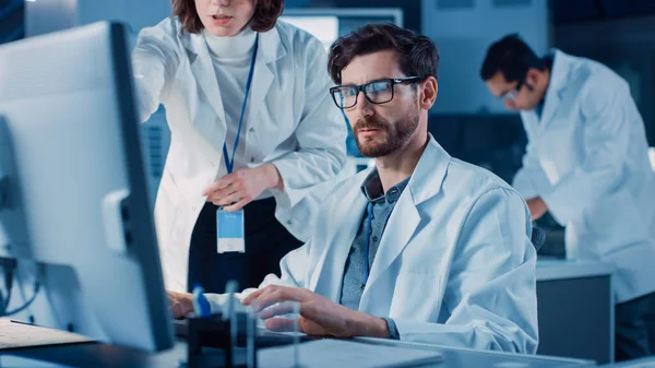 기계 엔진 개발 엔지니어 컴퓨터에서 그 의 Desk, Project Manager 와의 대화 , Shows Prototype Component. Team of Professionals working in the Modern Industrial Design Laboratory — 스톡 사진