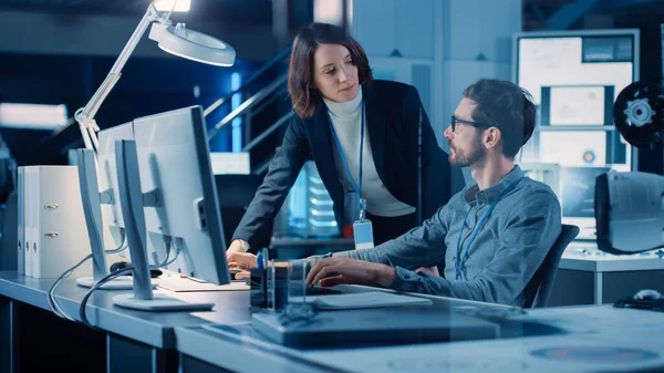Futuristic Machine Engine Development Engineer Working on Computer at His Desk, Talks with Female Project Manager. Team of Professionals Working in the Modern Industrial Design Institution — Stock Photo, Image