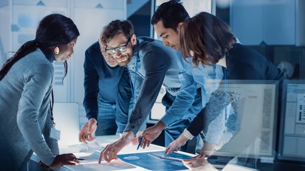 Reunião de Engenheiros em Laboratório de Pesquisa Tecnológica: Engenheiros, Cientistas e Desenvolvedores Reunidos em torno da Mesa de Conferências Iluminada, Solução de Conversação e Pesquisa, Inspeção e Análise — Fotografia de Stock