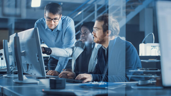 Electronics Development Engineer Working on Computer, Talks with Project Manager, Another Specialist Joins Discussion. Team of Professionals Use CAD Software for the Modern Industrial Engineering