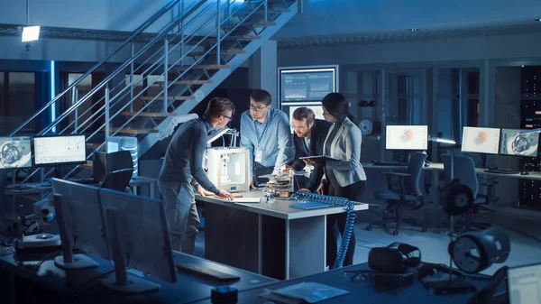Diverse équipe d'ingénieurs de développement électronique debout sur le bureau avec imprimante 3D et cartes mères PCB. Spécialistes travaillant collectivement sur le design industriel moderne, en utilisant les derniers appareils tablettes — Photo
