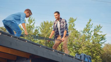 Baba ve Oğul, Metal bir havzaya güneş panelleri kuruyor. Güneşli bir günde panelleri bir çatı katında tutuyorlar. Ev ve Kaliteli Aile Zamanında Ekolojik Yenilenebilir Enerji Konsepti.