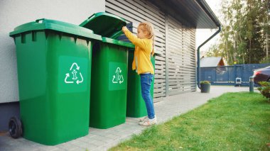 Genç Kız Boş Plastik Şişe 'yi Çöp Kutusu' na atıyor. Çöp kutusunu doğru kullanıyor çünkü bu aile çöpleri ayırıyor ve çevreyi korumaya yardım ediyor..