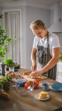 Beyaz Gömlekli ve Önlüklü Yakışıklı Modern Sunny Kitchen 'da Sağlıklı Organik Salata Yemekleri Yapıyor. Gözlüklü hippi aşçı. Doğal Temiz Diyet ve Sağlıklı Yaşam Konsepti.