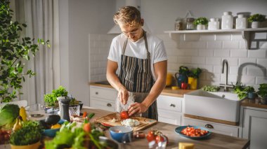 Beyaz Gömlekli ve Önlüklü Yakışıklı Modern Sunny Kitchen 'da Sağlıklı Organik Salata Yemekleri Yapıyor. Gözlüklü hippi aşçı. Doğal Temiz Diyet ve Sağlıklı Yaşam Konsepti.