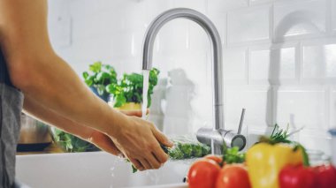 Yeşil Ispanak Yıkayan Bir Adamın Yakın Çekimi Musluk Suyuyla Çıkıyor. Sağlıklı sebzeli otantik stil mutfak. Organik Tarım 'dan Doğal Temiz Ürünler Elle Yıkandı.