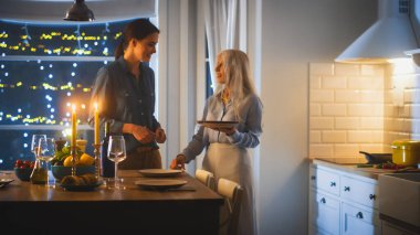 Mutfakta yemek hazırlayan ve servis yapan çok nesilli güzel kadınlar. Büyükanne, Kız Eğleniyor, Birlikte Yemek Yapıyor, Konuşuyor, Sırları Paylaşıyor ve Yemek Tariflerini Paylaşıyor