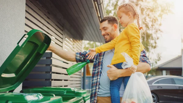 Father Holding a Young Girl and Throw Away an Empty Bottle and Food Waste into the Trash. They Use Correct Garbage Bins Because This Family is Sorting Waste and Helping the Environment. — Stock Photo, Image