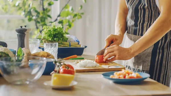 Närbild Skott av en man Hacka en tomat med en Sharp Kitchen Kniv. Förbereda en hälsosam ekologisk sallad måltid i ett modernt kök. Naturlig ren kost och hälsosam livsstil koncept. — Stockfoto