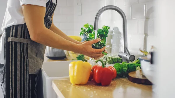 Κοντινό πλάνο ενός άνδρα που πλένει φύλλα πράσινου σπανάκι με νερό βρύσης. Αυθεντική κομψή κουζίνα με υγιεινά λαχανικά. Φυσικά καθαρά προϊόντα βιολογικής γεωργίας που πλένονται με το χέρι. — Φωτογραφία Αρχείου