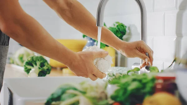 Primer plano de una persona que lava la coliflor con agua del grifo. Auténtica cocina elegante con verduras saludables. Productos naturales limpios de la agricultura ecológica lavados a mano. — Foto de Stock