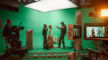 On Big Film Studio Professional Crew Shooting Period Costume Drama Movie. On Set: Director Explains Scene to Woman Actress Playing Renaissance Lady and Actor Wearing Motion Capture Suit clipart