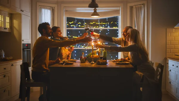 Счастливая семья празднуют вместе, сидя за столом едят вкусный ужин. Маленький ребенок, молодой муж, жена, дедушка и бабушка, Рассказы, Шутки, Поднятие бокалов к тосту — стоковое фото