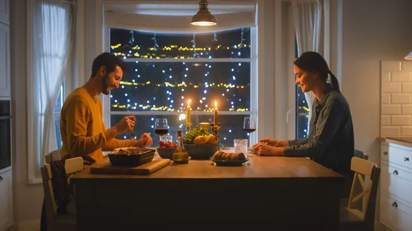 Счастливая молодая влюбленная пара ужинает, вкусно ужинает в Китчене, разговаривает. Любимый муж и жена не теряют времени даром — стоковое фото