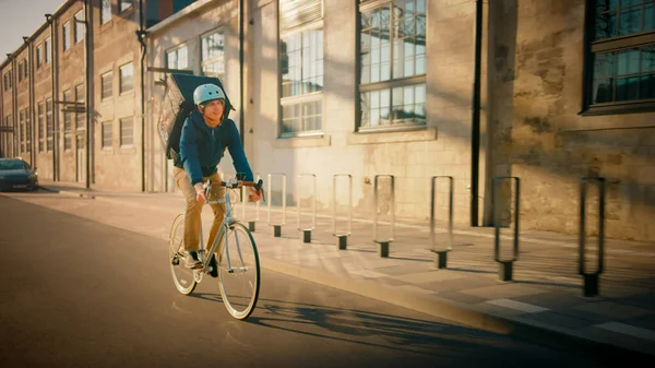 Happy Food Delivery Courier Usar Mochila Térmica Monta uma Bicicleta na Estrada Para Entregar Encomendas para Clientes e Clientes. Distrito da cidade moderna. — Fotografia de Stock