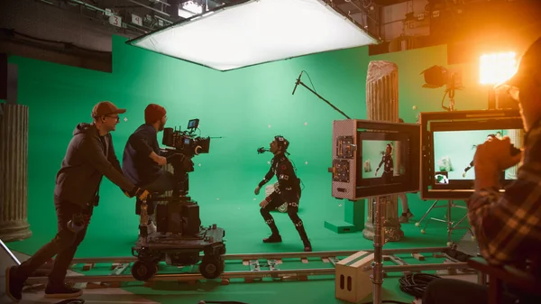 Dans le film Big Film Studio Professional Crew Shooting Blockbuster. Le réalisateur commande au cameraman de commencer à tourner une scène CGI à écran vert avec un acteur portant un costume de suivi de mouvement et une plate-forme de tête — Photo