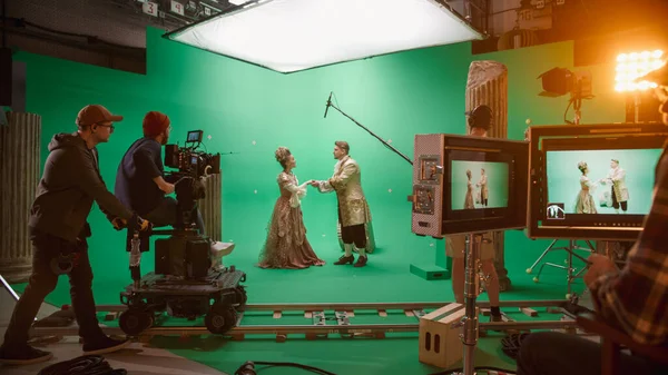 On Big Film Studio Professional Crew Shooting History Costume Drama Movie (en inglés). En el set: El director controla al camarógrafo que dispara una escena de pantalla verde con dos actores talentosos que usan ropa renacentista hablando — Foto de Stock