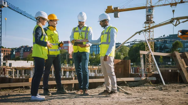 Diversi team di specialisti utilizzano computer tablet sul cantiere. Progetto di Costruzione Immobiliare con Ingegnere Civile, Architetto, Investitore Commerciale e Piano Generale di Discussione dei Lavoratori Dettagli. — Foto Stock