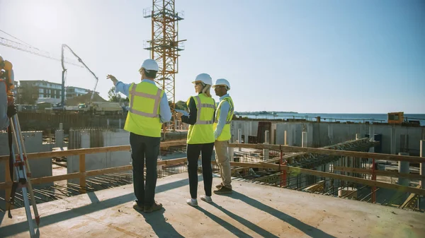 Equipo Diverso de Especialistas están en el sitio de construcción. Proyecto de construcción inmobiliaria con Ingeniero Civil, Arquitecto, Finanzas Empresariales Inversionista discutiendo detalles de planificación y desarrollo. — Foto de Stock