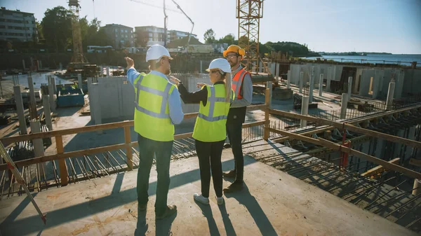 Diversi team di specialisti sono in cantiere. Progetto di Costruzione Immobiliare con Ingegnere Civile, Architetto, Finanza Aziendale Investitore discutendo Pianificazione e Sviluppo Dettagli. — Foto Stock