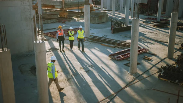 Equipo Diverso de Especialistas Dando un Paseo por el Sitio de Construcción. Proyecto de construcción inmobiliaria con Ingeniero Civil Senior, Arquitecto, Trabajador General Discutiendo detalles de planificación y desarrollo. — Foto de Stock