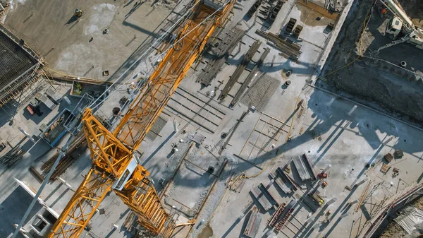 Vista aérea de un sitio de desarrollo de nuevas construcciones con grúas de torre alta Building Real Estate. Maquinaria pesada y trabajadores de la construcción están empleados. — Foto de Stock