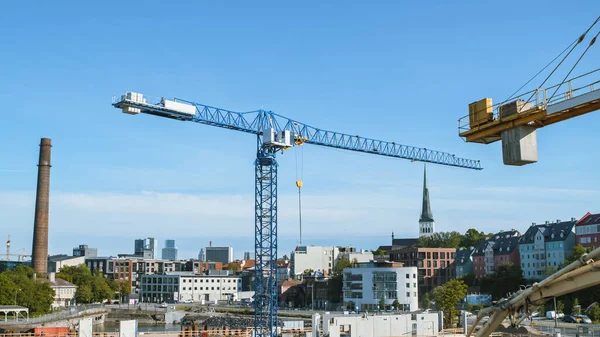Aerial Shot of a New Constructions Development Site with High Tower Cranes Building Real Estate. Se emplean trabajadores de maquinaria pesada y construcción. Casas de ciudad en el fondo. — Foto de Stock
