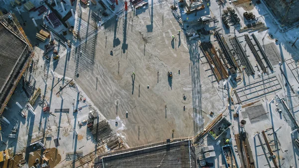 Scatto aereo di un nuovo cantiere di costruzione sito di sviluppo con gru a torre alta costruzione immobiliare. Vengono impiegati macchinari pesanti e operai edili. Vista dall'alto verso il basso. — Foto Stock