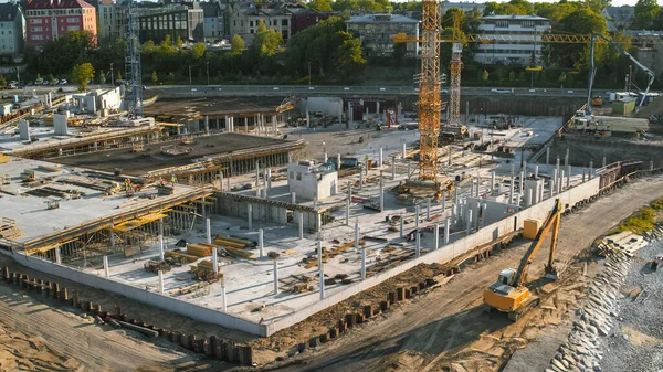 Aerial Shot of a New Constructions Development Site with High Tower Cranes Building Real Estate. Se emplean trabajadores de maquinaria pesada y construcción. Casas de ciudad en el fondo. — Foto de Stock