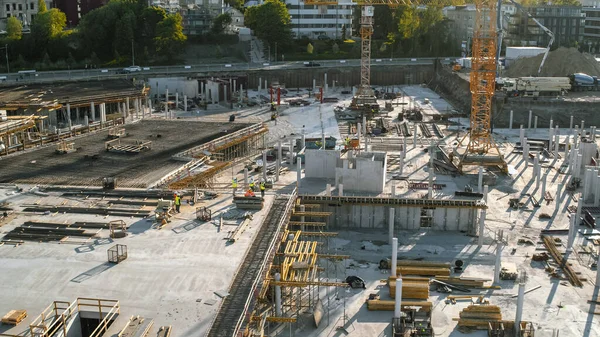 Aerial Shot of a New Constructions Development Site with High Tower Cranes Building Real Estate. Se emplean trabajadores de maquinaria pesada y construcción. Casas de ciudad en el fondo. — Foto de Stock