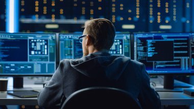 Monitörler Kodlama Dili Programı 'nı gösteren kişisel bilgisayar üzerinde çalışan bilişim uzmanı. Sunucu Raflı Veri Merkezinin Teknik Odası.