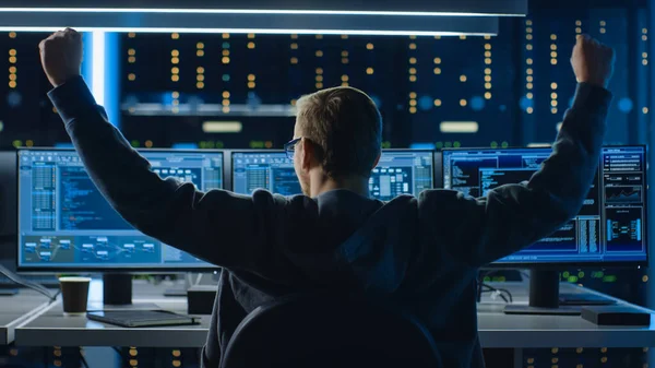 IT-Spezialist, der an Personal Computer mit Monitoren arbeitet, die Programmiersprache zeigen, feiert seinen Erfolg mit JA-Geste. Technischer Raum des Rechenzentrums. — Stockfoto