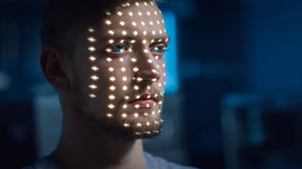 Handsome Young Caucasian Man is Identified by Biometric Facial Recognition Scanning Process. Futuristic Concept: Projector Identifies Individual by Illuminating Face by Dots and Scanning with Laser
