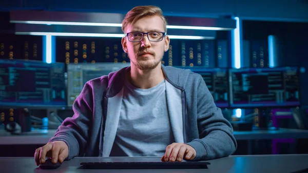 Retrato del desarrollador de software Hacker con gafas sentadas en su escritorio y trabajando en la computadora en el centro de datos de ciberseguridad de identidad digital. Hacking o Programación. —  Fotos de Stock