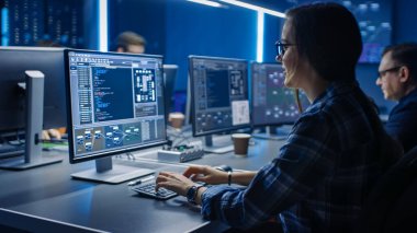 Data Center Sistem Kontrol Odası 'nda Masaüstü Bilgisayarı üzerine çalışan Akıllı Bayan Bilişim Programcısı. Kod Programı Yapan Genç Profesyoneller Ekibi
