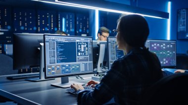 Data Center Sistem Kontrol Odası 'nda Masaüstü Bilgisayarı üzerine çalışan Akıllı Bayan Bilişim Programcısı. Kod Programı Yapan Genç Profesyoneller Ekibi