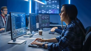 Data Center Kontrol Odası 'nda Masaüstü Yeşil Model Bilgisayar' da çalışan Akıllı Genç Bayan Bilişim Programcısı. Sofistike Kod Programlama Genç Profesyoneller Ekibi