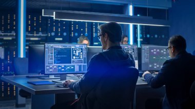 Veri Merkezi Kontrol Odası 'nda Masaüstü Bilgisayarları üzerinde çalışan bilişim programcıları ekibi. Sofistike Programlama Kodu Dili Yazan Genç Profesyoneller