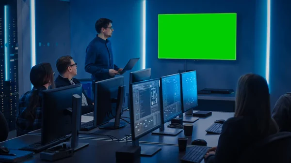 Team professioneller IT-Entwickler trifft sich, Redner spricht über neue Konzepte, On Wall TV hat einen grünen Mock-up-Bildschirm. Konzept: Softwareentwicklung, Deep Learning, Künstliche Intelligenz — Stockfoto