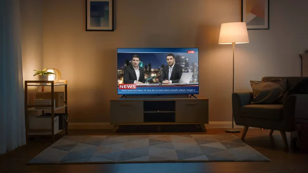 Grabación de un televisor con Live News Channel. Acogedora sala de estar durante el día con una silla y lámparas encendidas en casa. — Foto de Stock