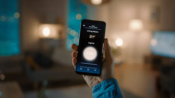 Zavřít snímek chytrého telefonu s aktivní aplikací Smart Home. Osoba dává hlasový povel k rozsvícení světel v místnosti. Jeho útulný večer v bytě. — Stock fotografie