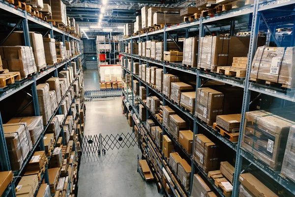 Grande armazém com fileiras de prateleiras e caixas de mercadorias . — Fotografia de Stock